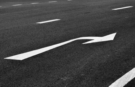 white arrow turn right sign on black asphalt. space transportation background