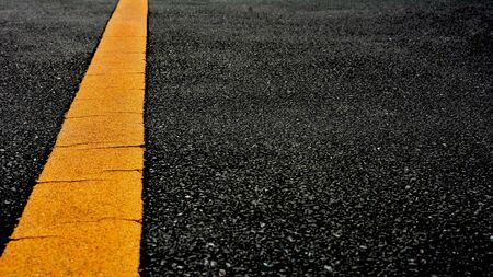 Yellow paint line on black asphalt. space transportation backgroundの写真素材