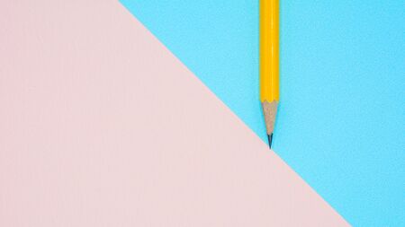 yellow pencil on blue and pink paperの写真素材