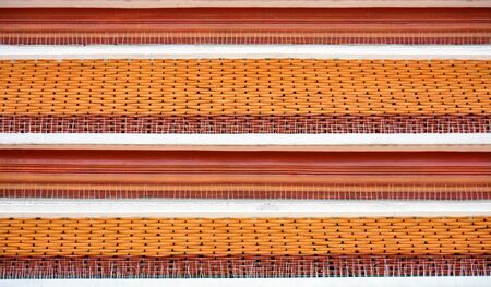 antique red and yellow tile roof pattern at the buddha temple in thailand