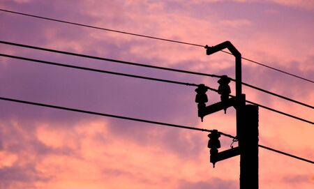 silhouette high voltage pole for industry in the city at evening timeの写真素材