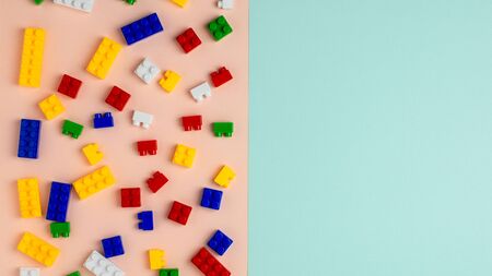 Plastic building blocks on blue and pink background