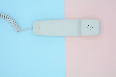 telephone receiver on blue and pink background