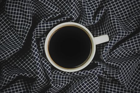 a cup of coffee and blue fabric plaid.の写真素材