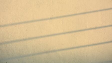 shadow of wire on old cement wall - sunset timeの写真素材