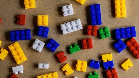 pile of plastic building blocks on brown paper backgroundの写真素材