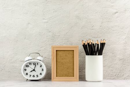 Classic wooden photo frame with a clock and a pencils in white coffee cup. - blank space for message...