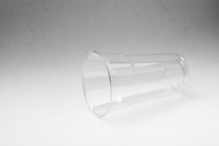 plastic water glass on dirty pale grey backgroundの写真素材