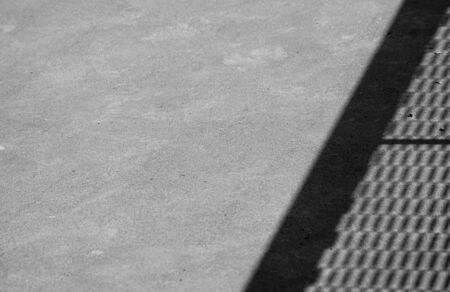 light and shadow of wire mesh on brick floor - monochromeの写真素材