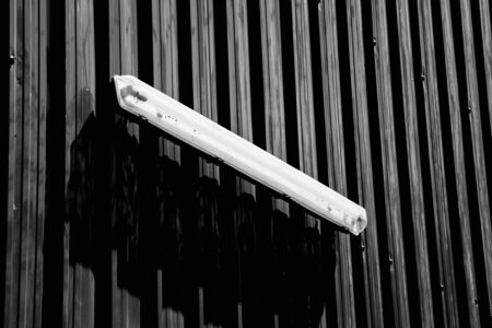 lamp on steel wall with shadow - monochromeの写真素材