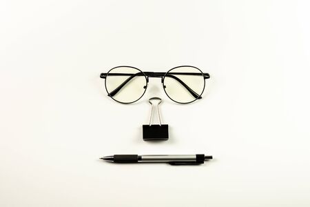 glasses, stamp paper clip and pen on white background. - office supplies and education concept.の写真素材