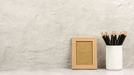 Classic wooden photo frame and a many pencils in white cup. - blank space for message and advertising background.の写真素材