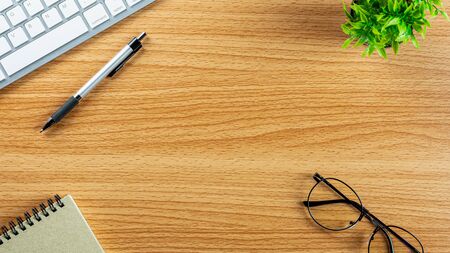 computer keyboard, pen, notebook and a glasses on wooden desk. - top view with copy space.の写真素材