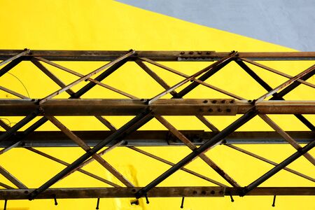 Detail of old rusty metal bridge on yellow and grey backgroundの写真素材