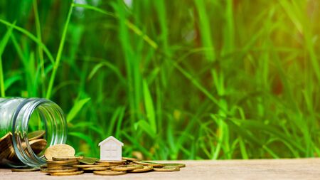 small house on pile of golden coins in the garden. - Concept of Investment property.の写真素材