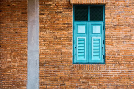 classic green and blue wood window at the antique brick building.の写真素材