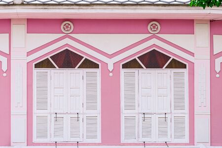 classic white and wood window at a pink concrete building.の写真素材
