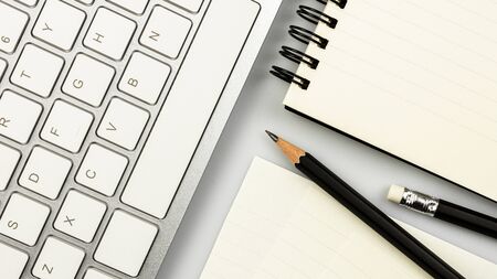 modern white office desk with a computer keyboard, pen, notebook and a paper. - top view with copy space.の写真素材