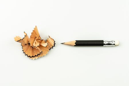 small used pencil with sharpening shavings on white background.