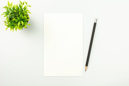 blank note paper and a pencil on white desk background.の写真素材