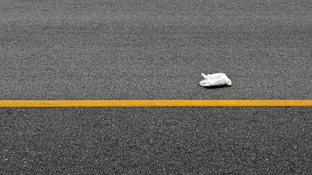 Garbage is discarded on the asphalt road in the city.の写真素材