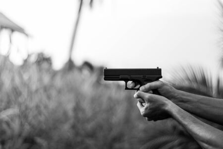 A man holding a gun in hand. - violence and crime concept.の写真素材