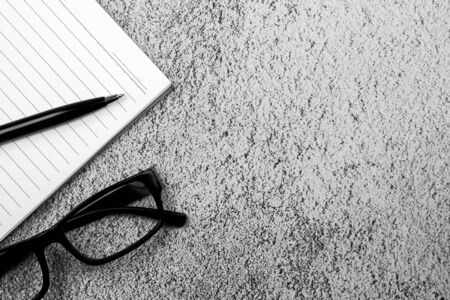 book, pen and a glasses on concrete desk. - for creative and business concept background.の写真素材