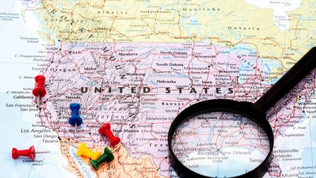magnifying glass on the world map at United States of America. - economic and business concept.の写真素材