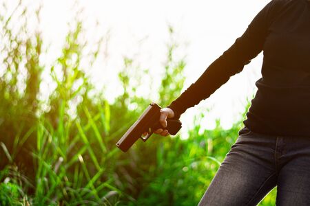 woman holding a gun in hand. - violence and crime concept.の写真素材