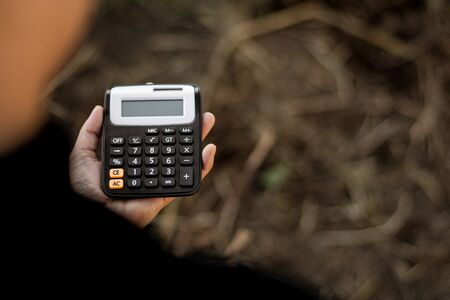 woman holding a calculator in a hand. - Saving money for finance accounting concept.の写真素材
