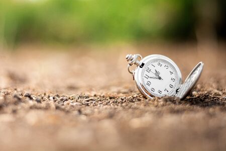 old pocket watch is discarded on the ground. - thinking and control timing ideas concept.の写真素材
