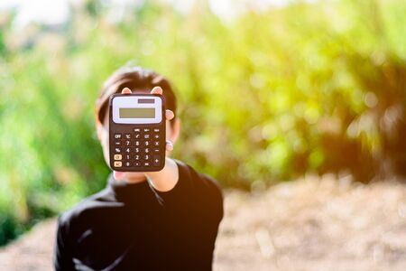 woman holding a calculator in a hand. - Saving money for finance accounting concept.の写真素材