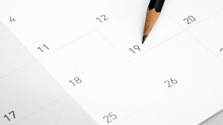 The pencil points to the 19 in the calendar.の写真素材
