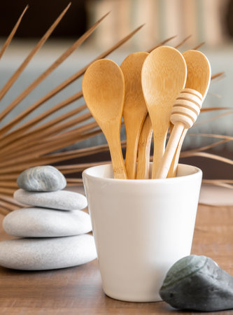 Bamboo spoons in cup on table, disposable tableware from natural materials, stones, zero waste concept. Place for text. High quality photoの写真素材