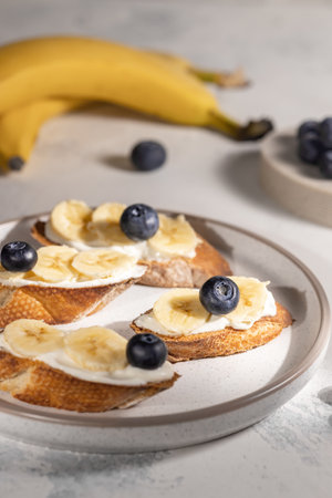 Healthy breakfast concept, banana sandwiches with blueberry on round plate on the table. Ingredients. High quality photoの写真素材
