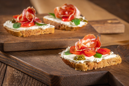 Italian tomato and cheese bruschetta. Antipasto with prosciutto and cherry tomato vegetables. High quality photoの写真素材