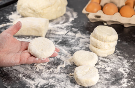 Close up of a woman making rolls and spreading dough preparing curd fritters, home cooking conceptの写真素材
