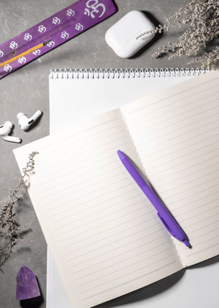 Top view of notepads pens and headphones on desk grey background with free copy spaceの写真素材
