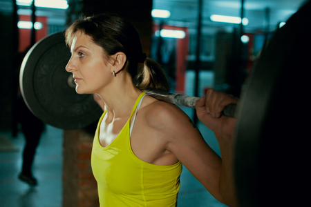 Beautiful fitness girl liftings weights.の写真素材