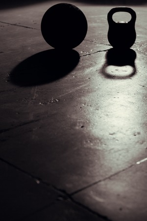 Kettlebell and ball backlight and shadow in gymの写真素材