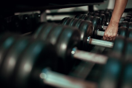 Young girl takes a dumbbell. Close up.の写真素材