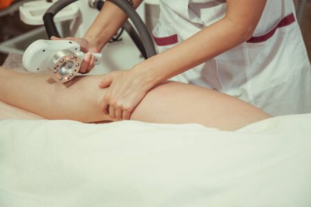 Beautician makes the vacuum massage cellulite young woman. Cosmetic procedure.
