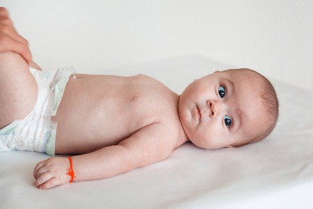The doctor massages the leg of a child on a white background. Baby massage