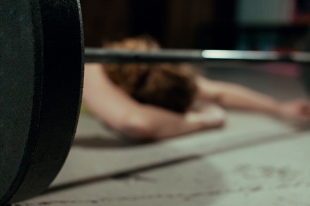 A girl rests after classes with a barbell in the gymの写真素材