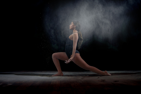 Dancing girl with flour on a black backgroundの写真素材