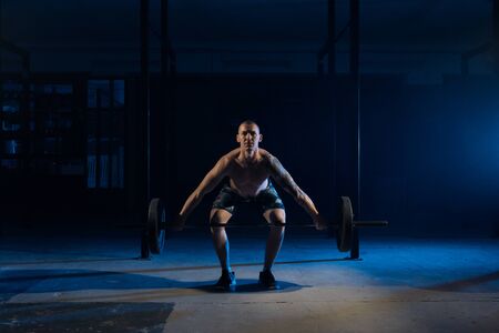 Strong man lifting a barbell in the gym.の写真素材