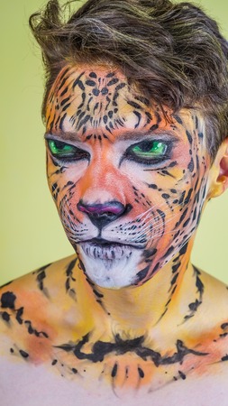 The guy with the painted face of a tiger on a bright background