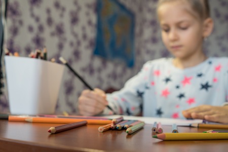 Attentive child writes with crayons on the album. Homework. Childrens creativity.の写真素材