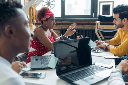 A team of young people of different nationalities discusses the work on the project in the office.の写真素材