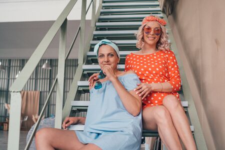 Sexy young girls in pin-up style pose on the stairs. Womens summer clothing.の写真素材